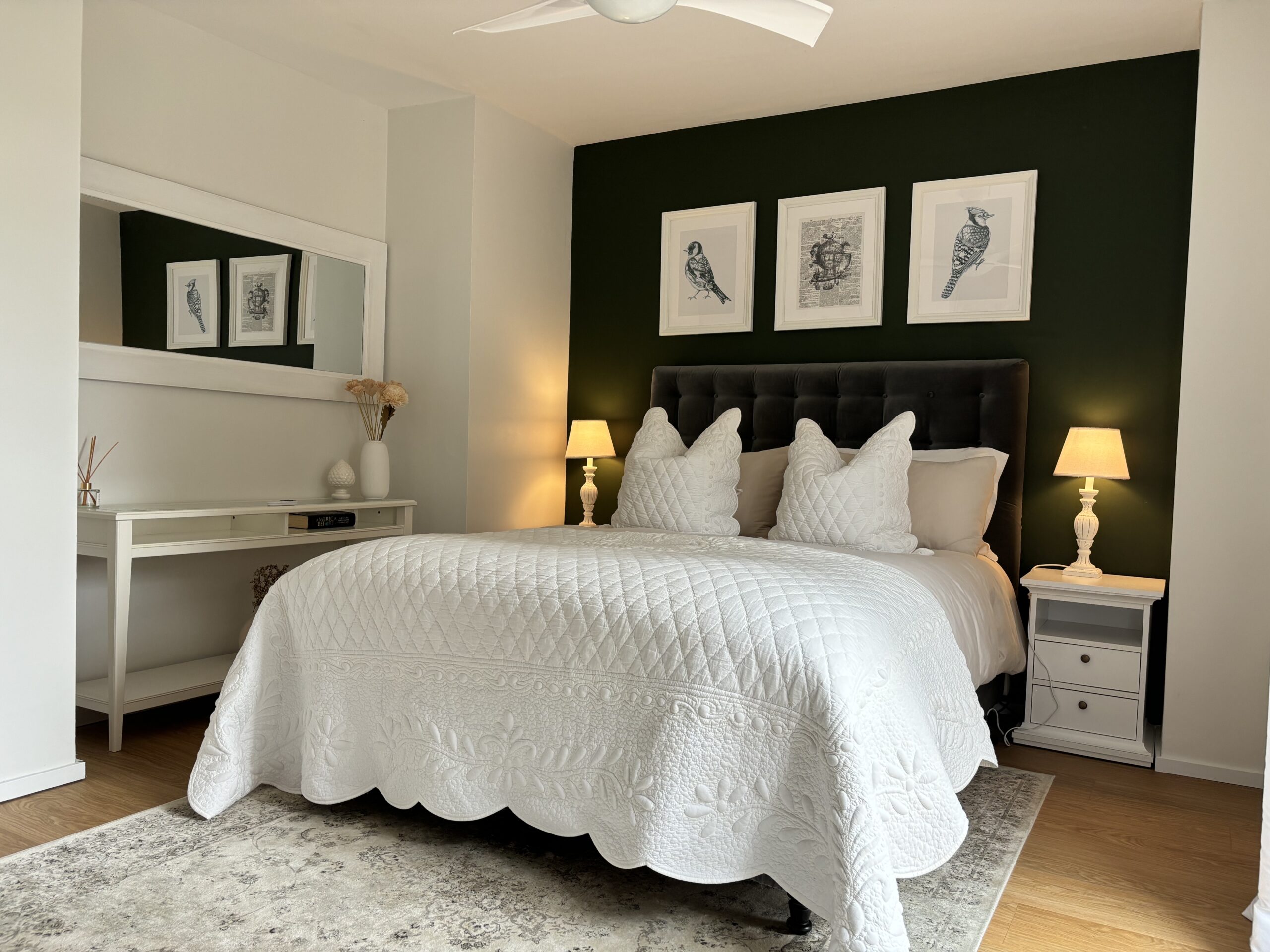 a bedroom with a white bed and a white fan