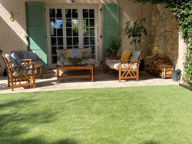 a patio with chairs and a green lawn